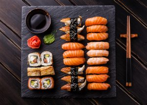 Sushi Set sashimi and sushi rolls on black stone slate